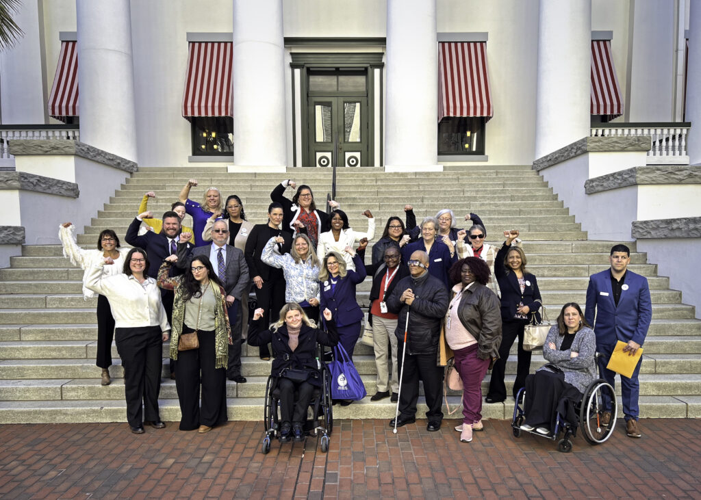 CIL representatives flex their muscles on steps of Old Capitol on CIL Day 2024